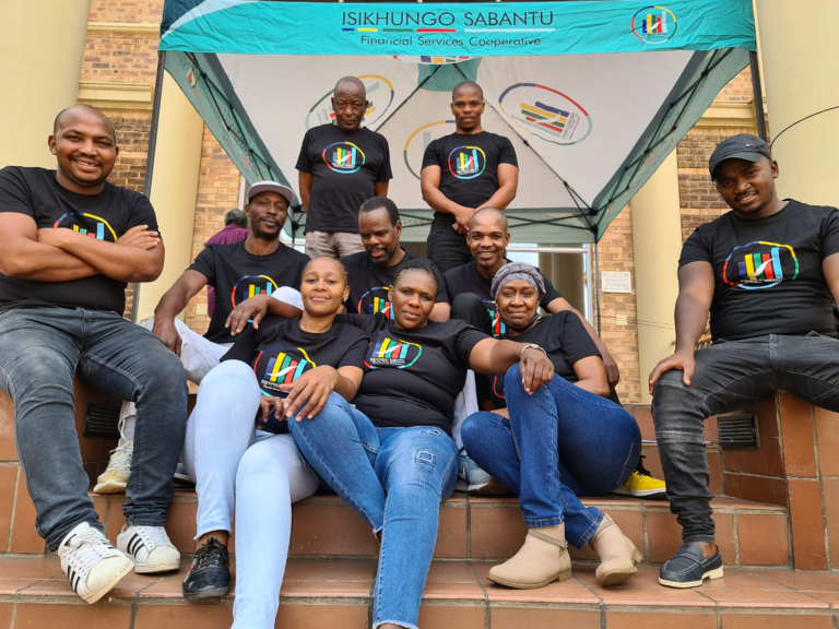 A group of shareholders from Isikhungo Sabantu Financial Services Cooperative (IS FSC) CFI under the IS FSC branded gazebo